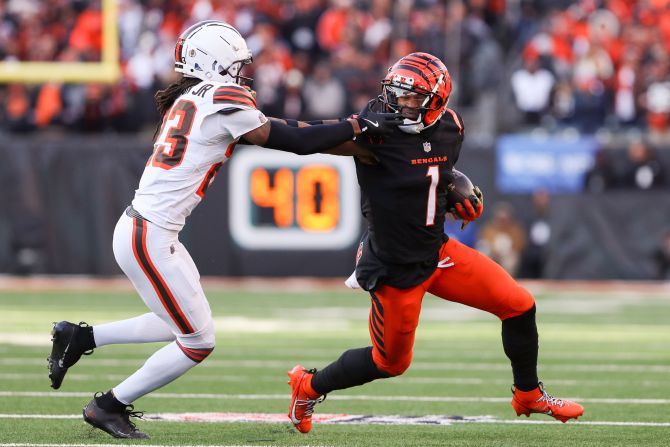 Cincinnati Bengals wide receiver Ja'Marr Chase carries the ball while being face masked by Cleveland Browns cornerback Martin Emerson Jr. in Cincinnati on December 22.