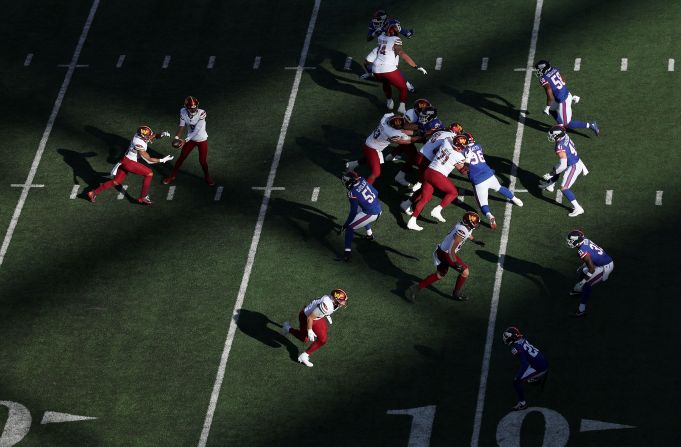 Washington Commanders quarterback Jayden Daniels fakes a hand off to running back Austin Ekeler during the game against the New York Giants on November 3.