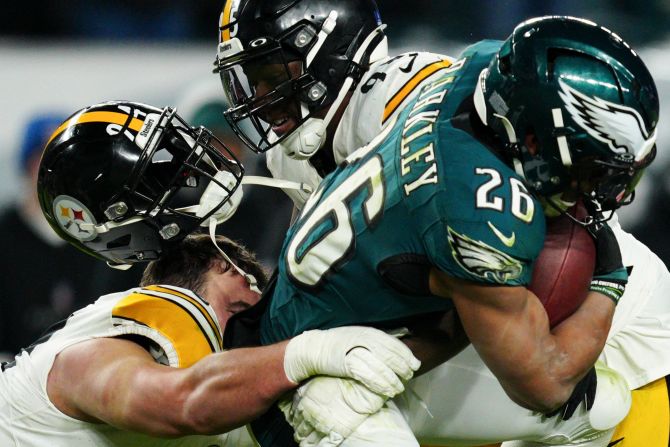 Pittsburgh Steelers defensive tackle Dean Lowry loses his helmet as he takes down Philadelphia Eagles running back Saquon Barkley in Philadelphia on Sunday, December 15. The Eagles won 27-13