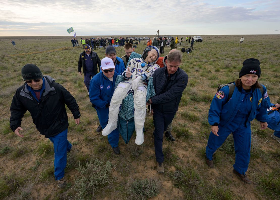 Mission support members carry NASA's Don Pettit to a medical tent shortly after he landed in a Soyuz spacecraft in Kazakhstan on Saturday. He returned from a mission on the International Space Station.