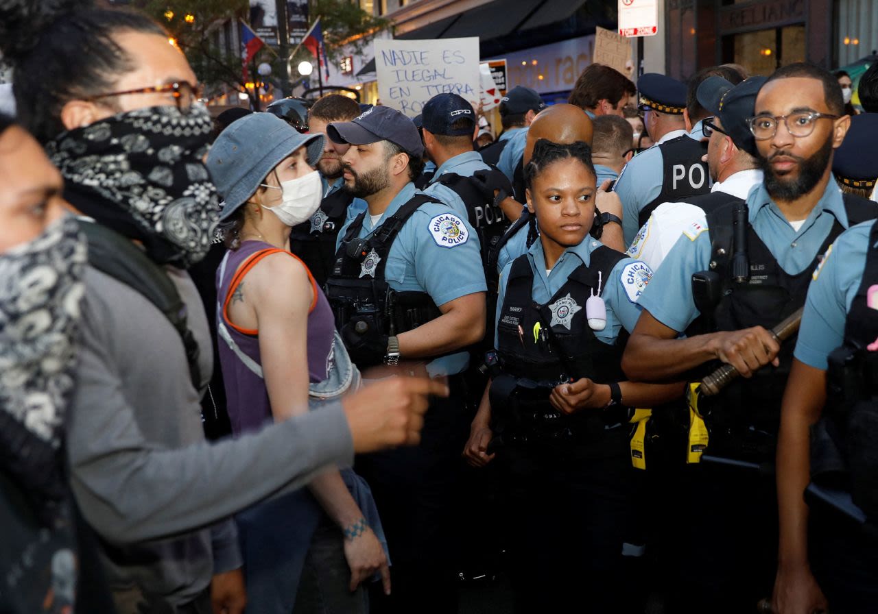 Personas se enfrentan a agentes de Policía mientras protestan contra las redadas federales de inmigración en Chicago el martes.