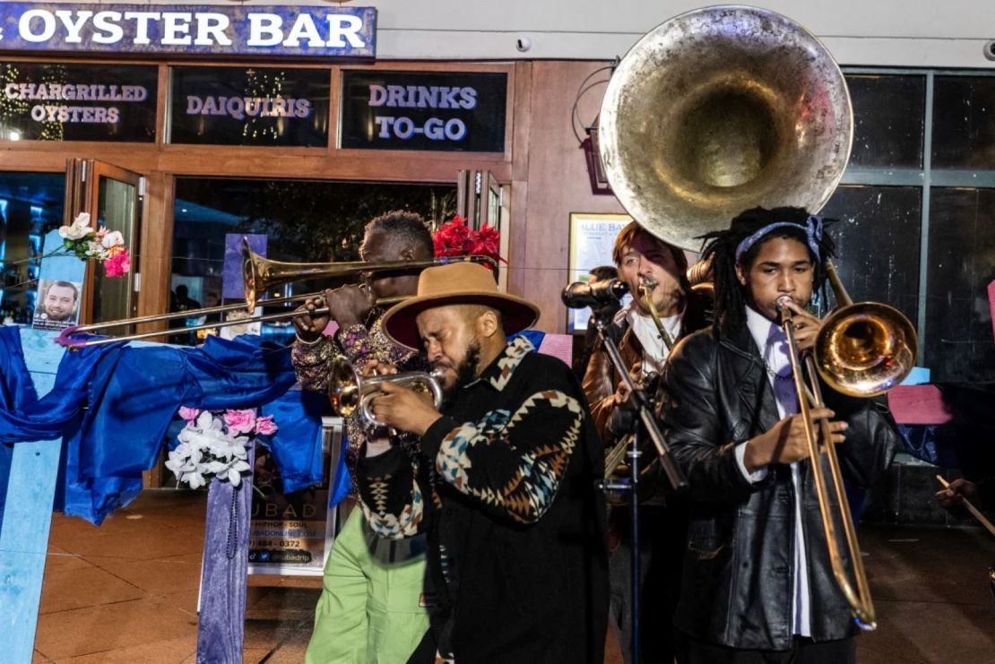 Una banda toca este jueves junto a cruces con fotos de las víctimas en un memorial en Bourbon Street.