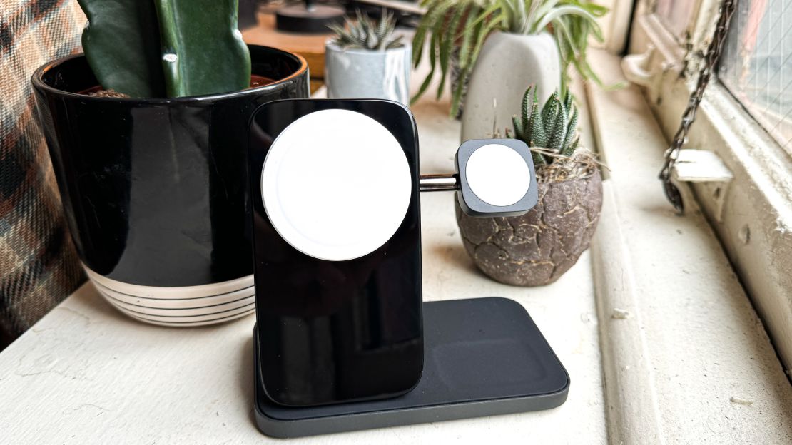 A charging stand on a windowsill with potted plants in the background.