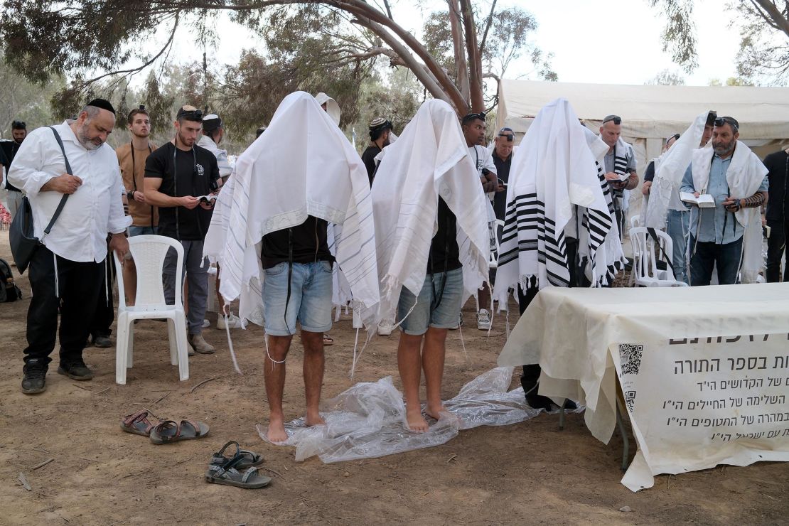 People pray for the victims of the October 7 terror attack at the site of the Nova Music Festival.