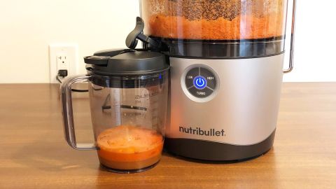 A NutriBullet Juicer Pro with a pitcher of fresh orange juice