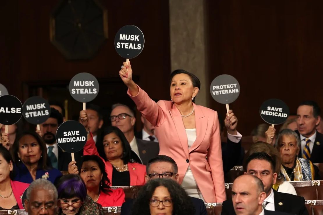 La representante Nydia Velázquez sostiene un cartel de protesta junto a otros demócratas mientras el presidente Donald Trump se dirige a una sesión conjunta del Congreso en el Capitolio de Estados Unidos el 4 de marzo en Washington.
