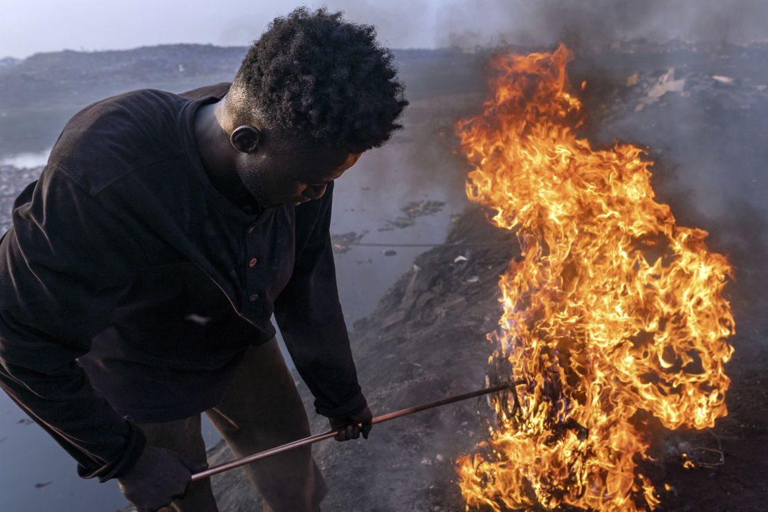 Simon Aniah, 24, burns scrap electrical cables to recover copper by the Korle Lagoon in Accra, Ghana, February 9, 2023.
