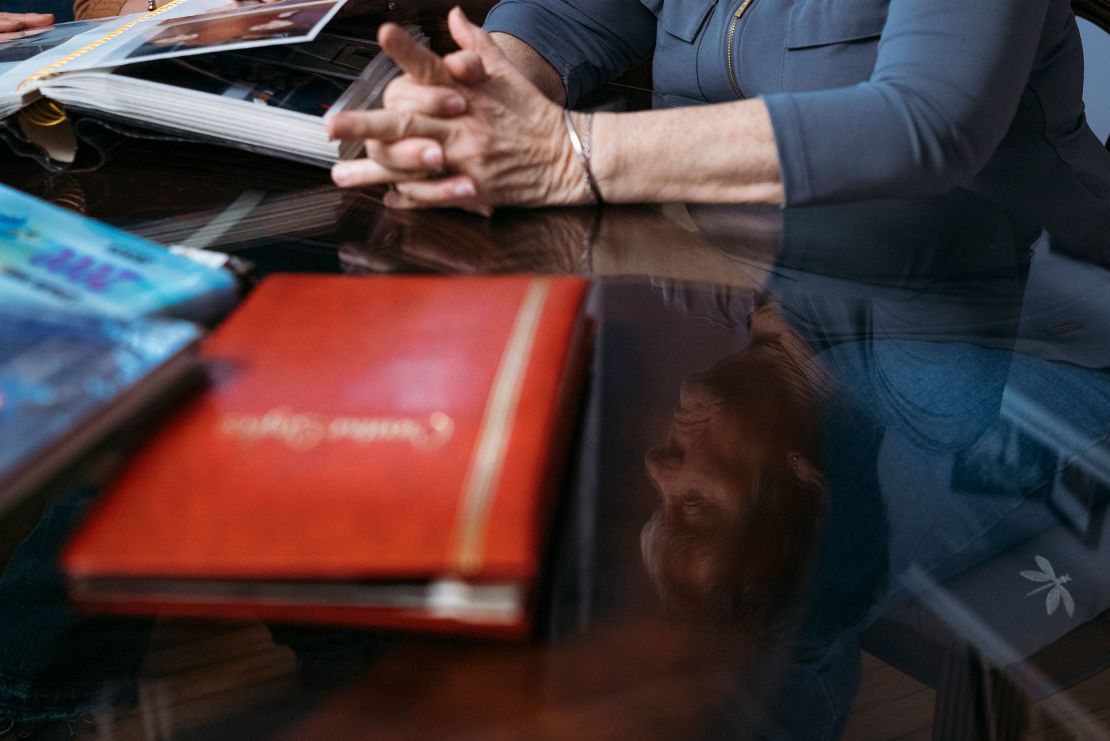 Maralee Hill watches as her daughter Victoria goes through old family photo albums at her home in Wethersfield, Connecticut.