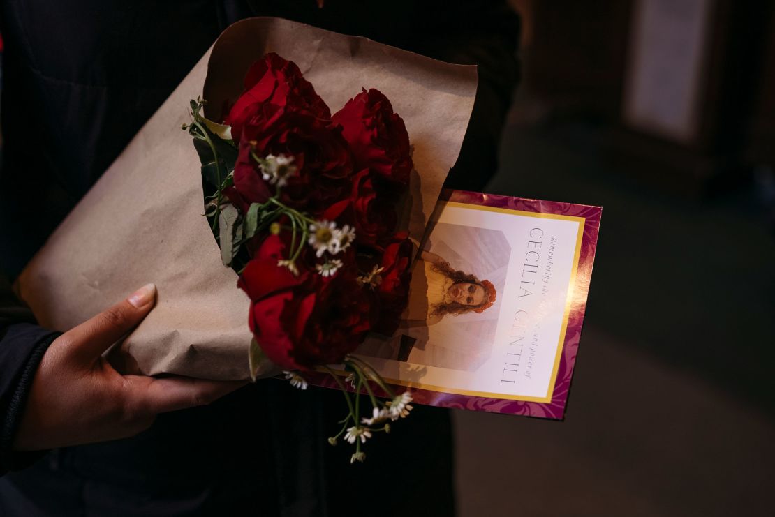 Maz George holds flowers and a pamphlet after Gentili's funeral. "As a former Catholic myself, I've never seen so many queer people in church,” they said.