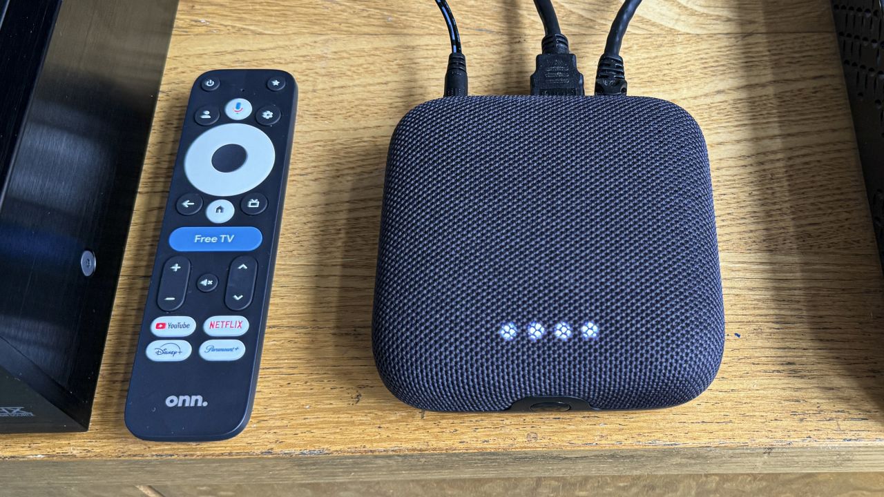 (R, L) the Onn 4K Pro google TV streaming box, with four white bubbles showing for voice commands next to its remote