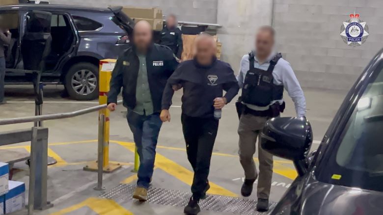 An image released by the AFP shows the male suspect being led by police.
