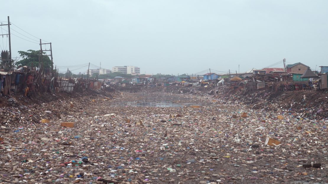 A water stream across the street from Kantamanto textile market is choked with discarded clothing, essentially becoming a makeshift landfill.