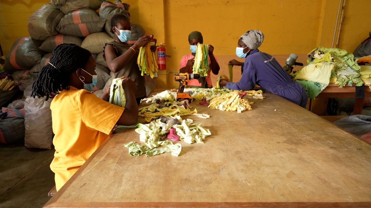 MacCarthy (on the left, in the yellow shirt) and members of her team from the Or Foundation assemble mops from discarded secondhand garments.