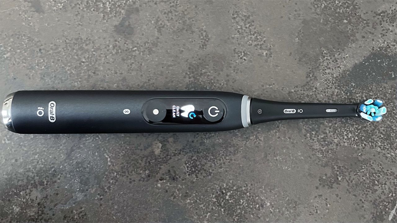 The Oral-B iO Series 9 smart electric toothbrush on a stone countertop