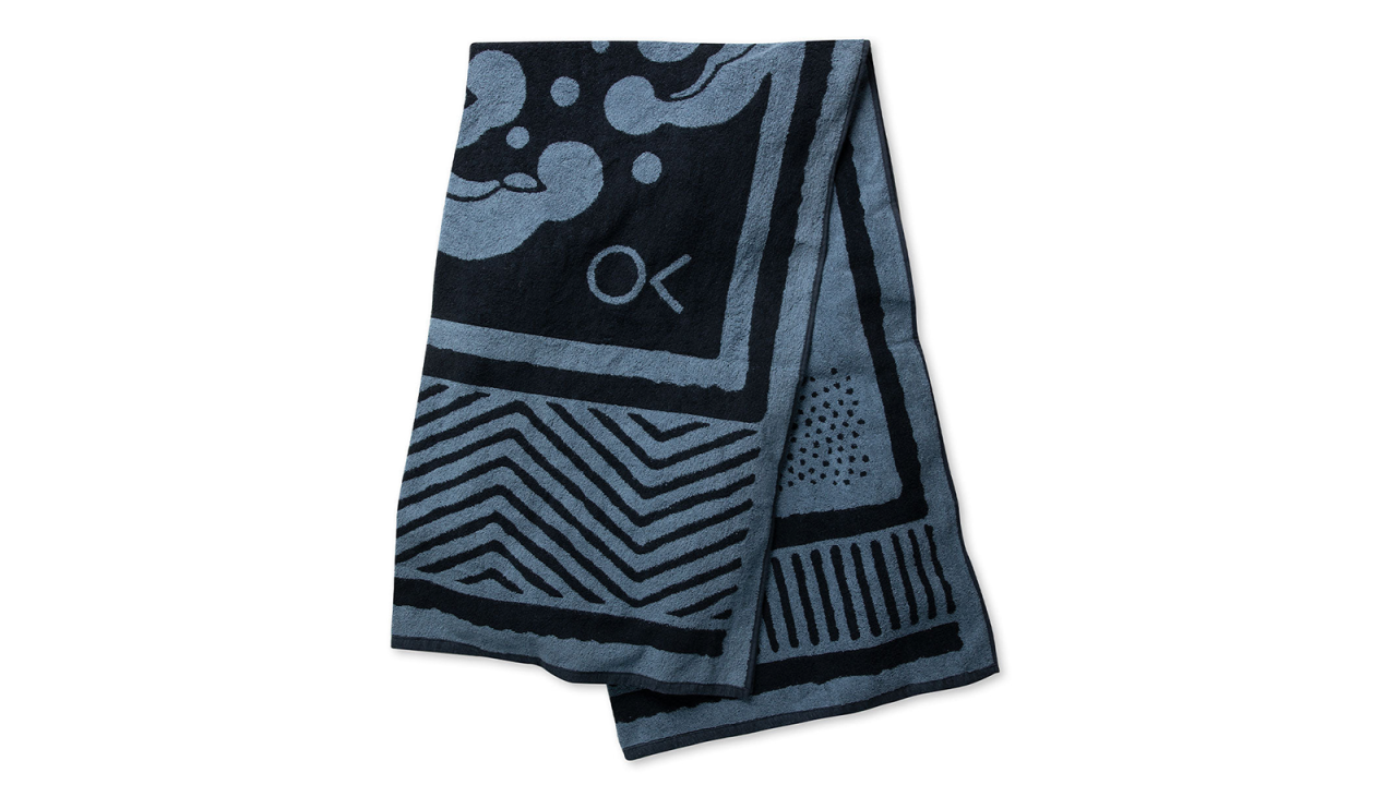 a gray and black patterned beach towel folded