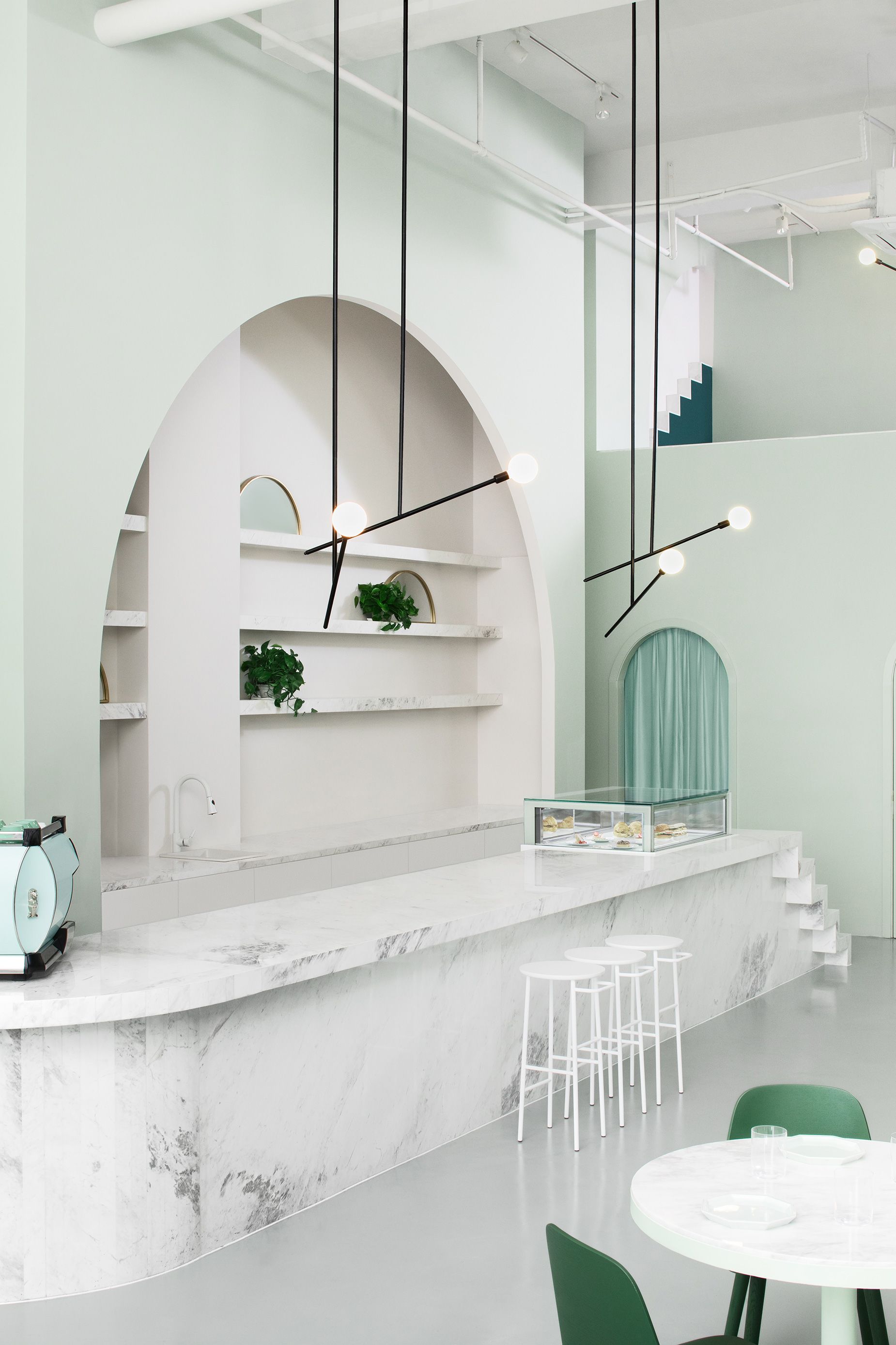 With its languid architectural lines and calming pastels, the Budapest Cafe encourages customers "to explore and physically engage with the space, much like a (film) set."