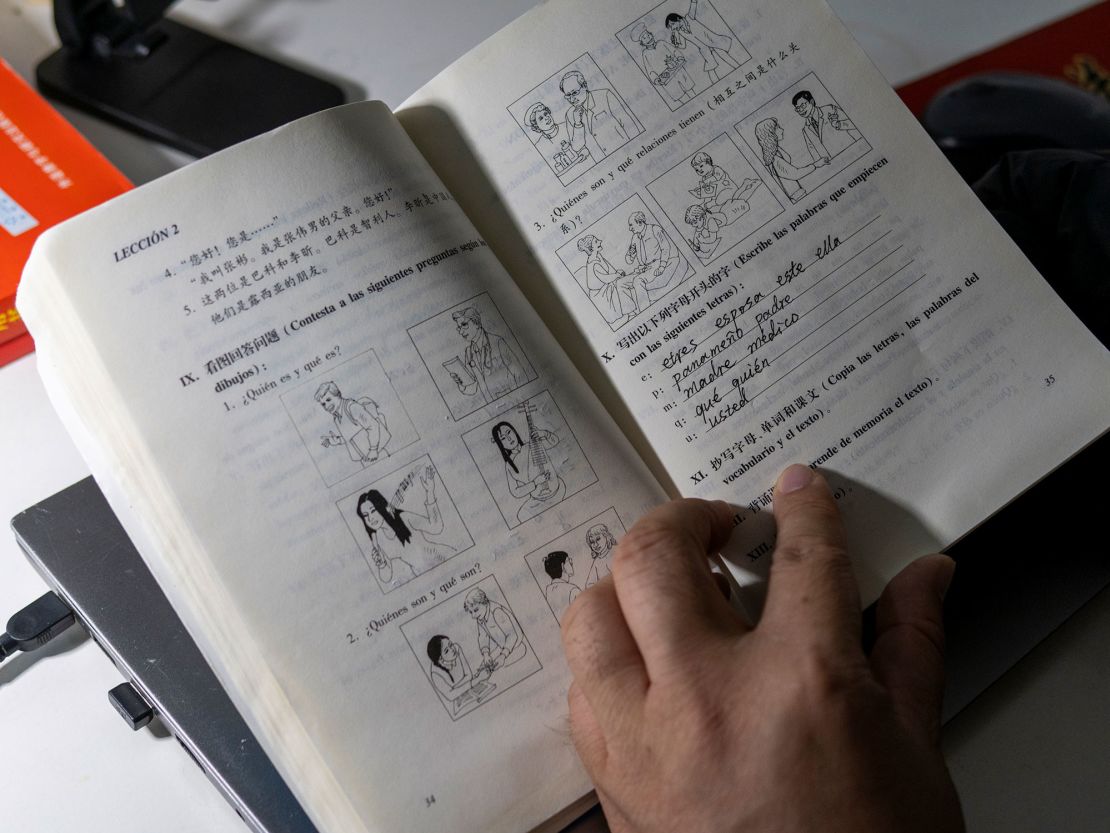 Zhang shows one of his workbooks helping him to learn Spanish.