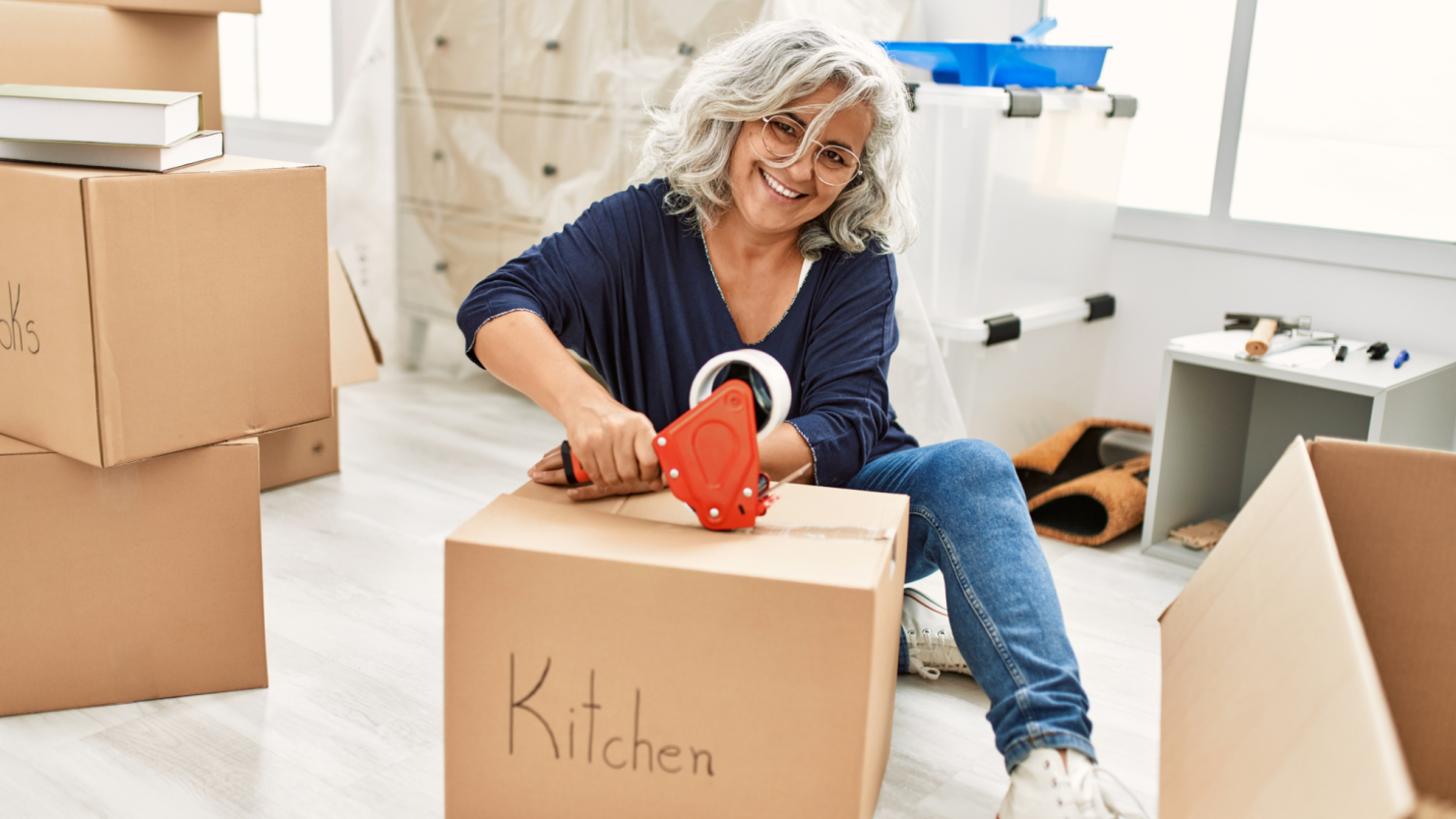 Woman packing cardboard moving box