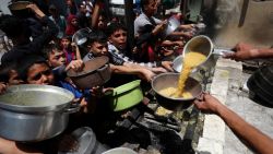 Palestinos esperan recibir comida cocinada por una cocina benéfica, en Jabalia en el norte de Gaza, el 19 de mayo de 2025.