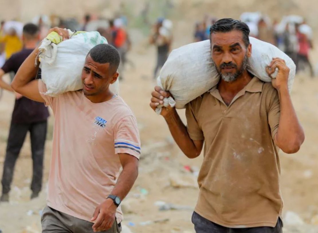 Palestinos llevan suministros de ayuda recolectados de la Fundación Humanitaria de Gaza (GHF), respaldada por Estados Unidos, en el centro de la Franja de Gaza el 1 de agosto.