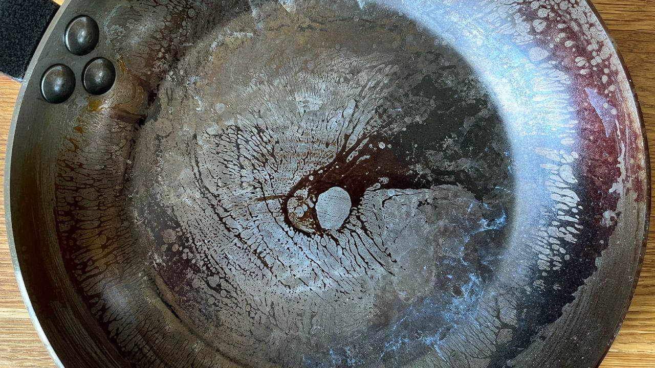 Close up of the seasoned surface of a carbon steel skillet.