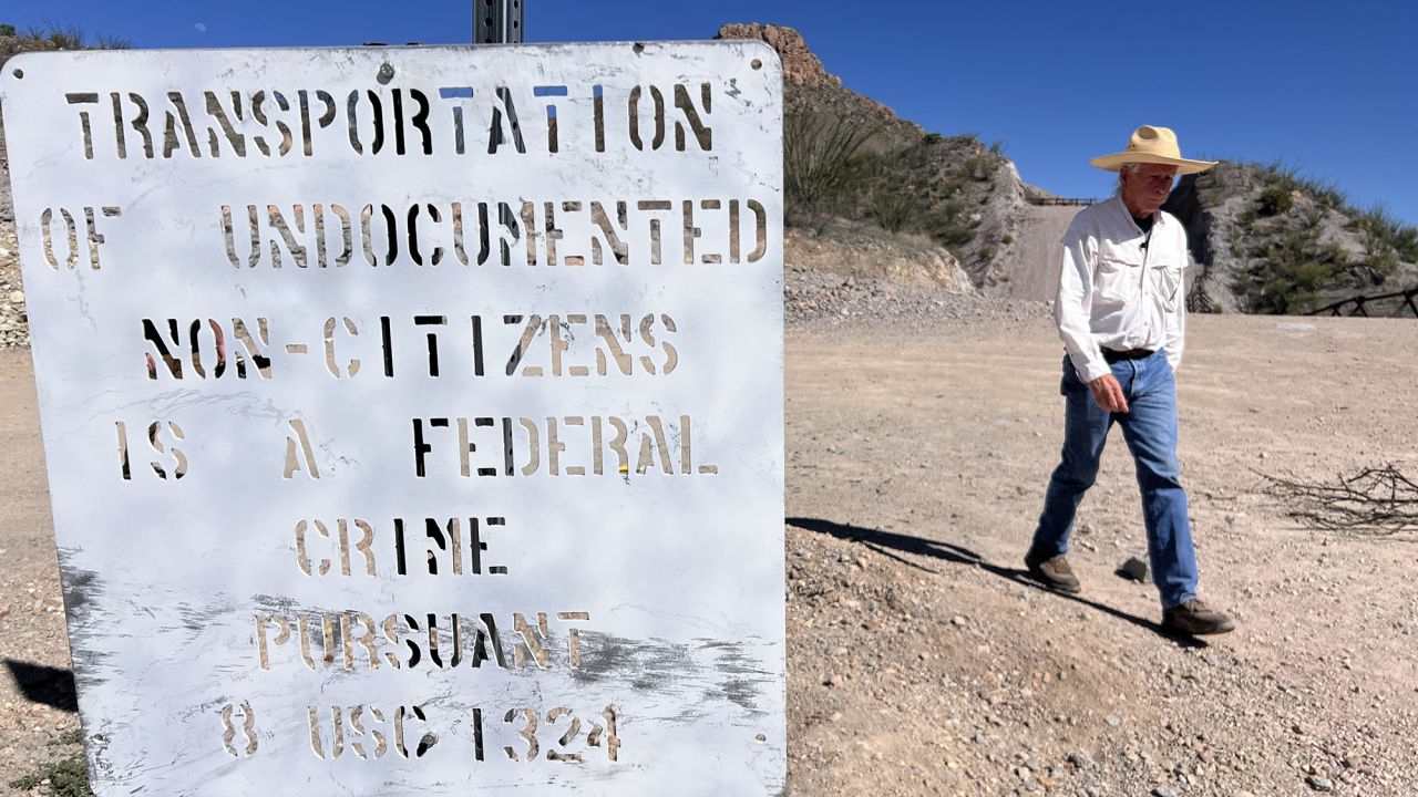 Paul Nixon walks by a sign posted by Border Patrol warning people that transporting migrants is a federal crime.