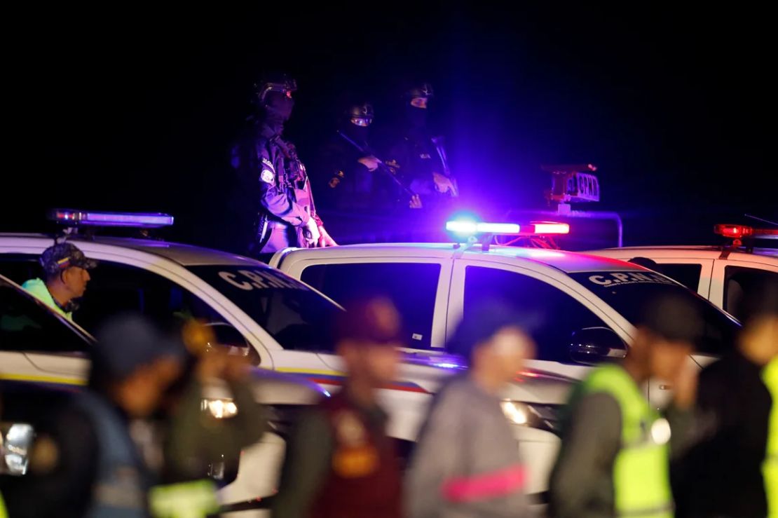 Personal de seguridad hace guardia durante el día en que migrantes venezolanos llegan en un vuelo después de ser deportados de Estados Unidos, en Caracas, Venezuela, el 24 de marzo de 2025.