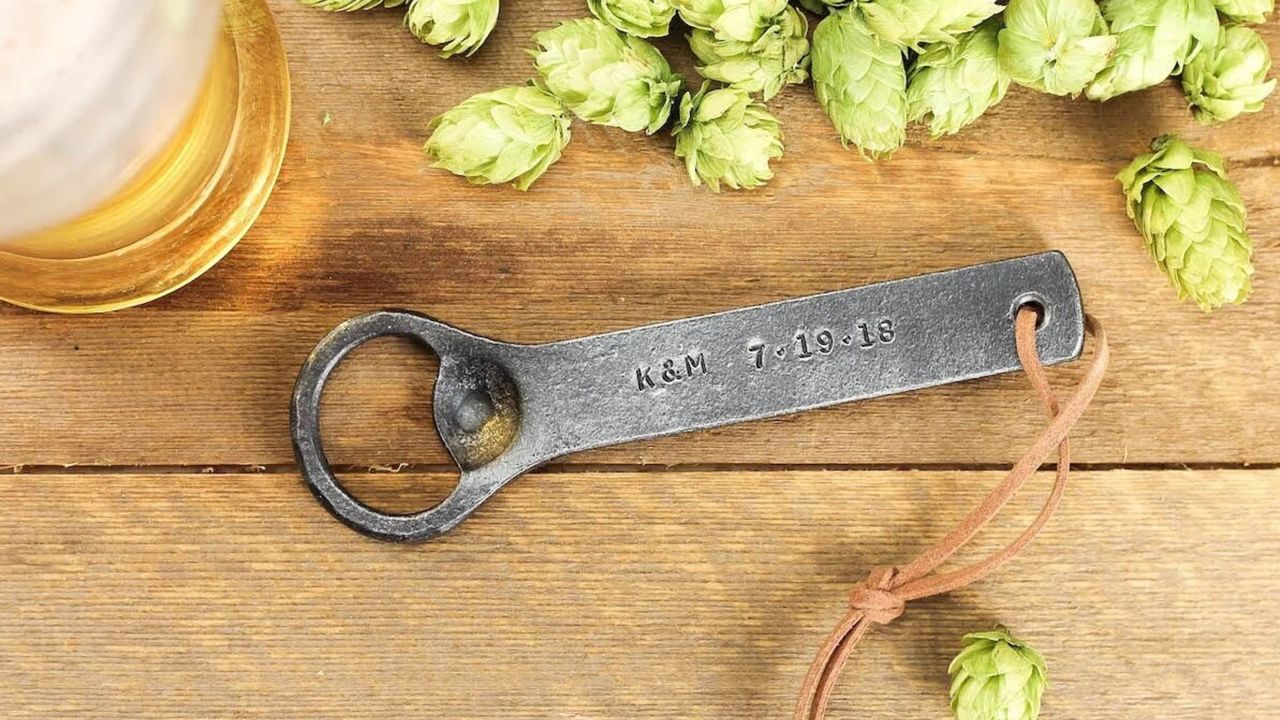 personalized bottle opener next to glass of beer and hops
