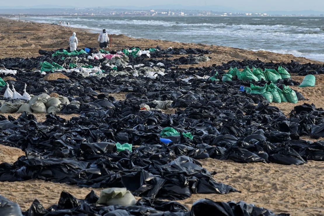 Voluntarios trabajan para limpiar el petróleo derramado en la costa rusa en el estrecho de Kerch, cerca del balneario de Anapa en el Mar Negro, el 21 de diciembre.