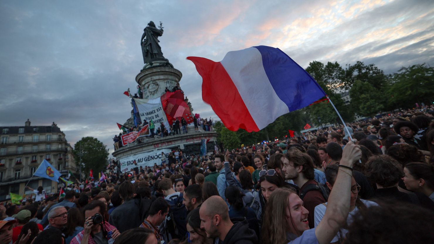 A person waves a French flag during a rally at Place de la République.
