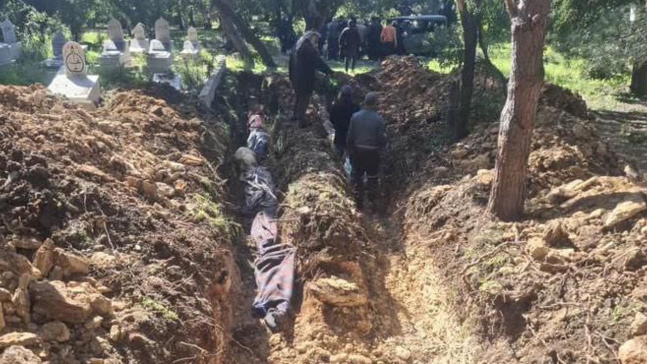 Bodies are laid in a mass grave in Pine village.