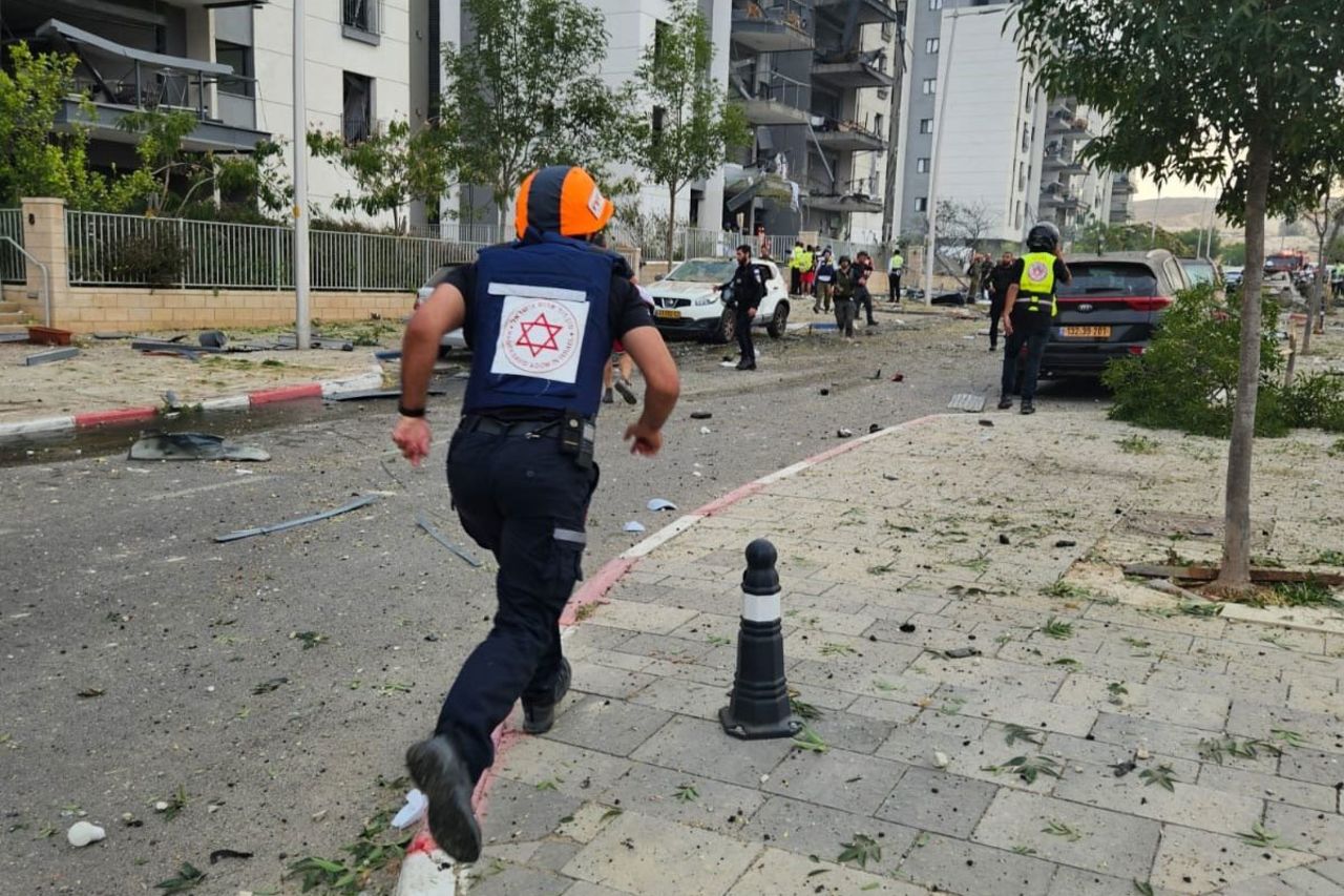 Magen David Adom'un bu dağıttığı fotoğrafta, Cuma günü İsrail'in Beer Şeva kentinde İran'ın gerçekleştirdiği füze saldırısının gerçekleştiği yerdeki bir acil durum görevlisi görülüyor.