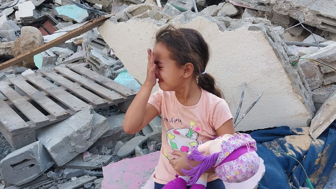 Saba, Al-Kahlot’s daughter, on the ruins of their house in Beit Lahia, in northern Gaza, on October 10, 2023.