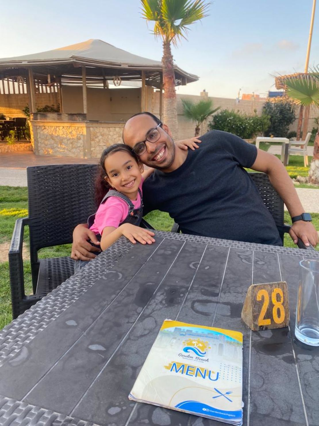Ella Mohammed Hamouda (left) and her father, Mohammed Hamouda (right) sit at a beachside restaurant in Beit Lahia, in northern Gaza, on June 26, 2023.