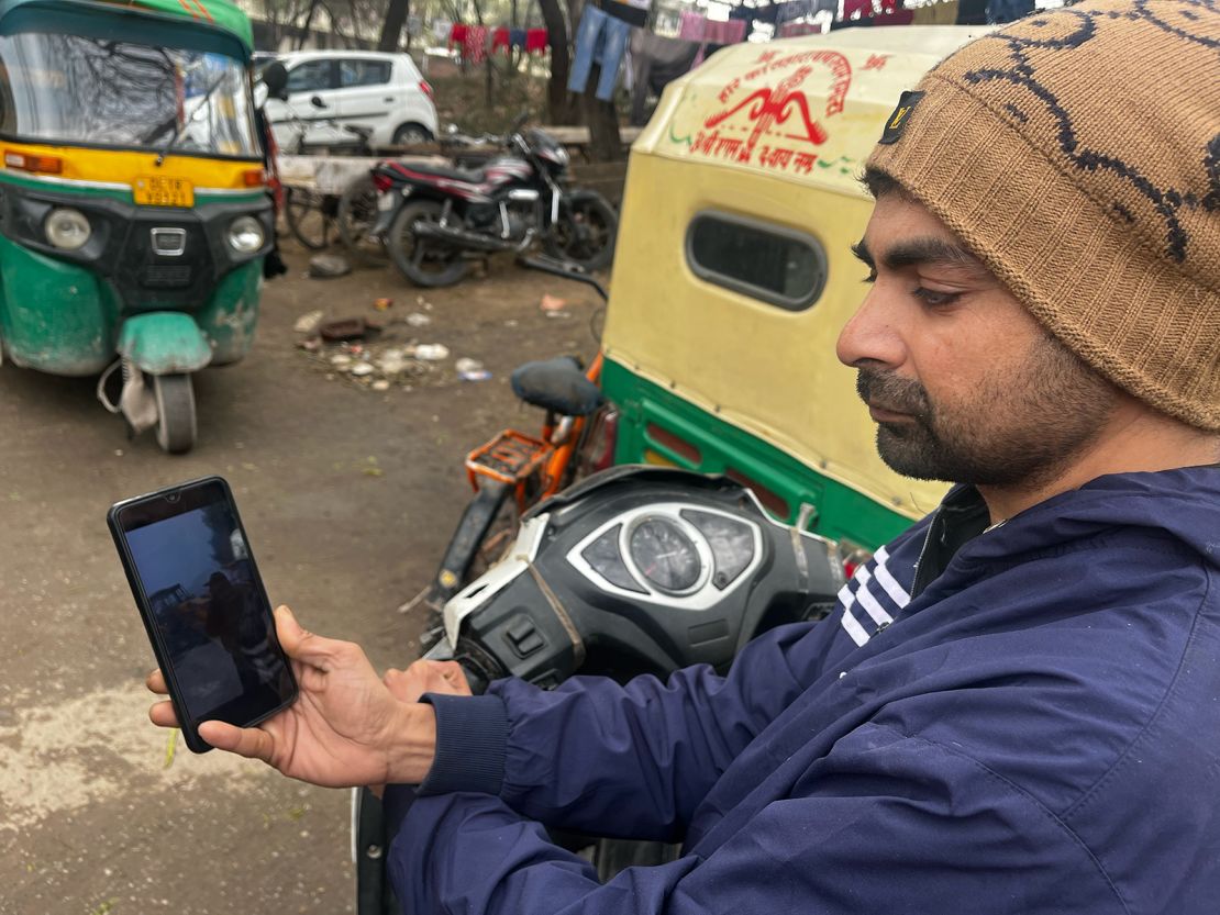 Mohammad Aman, a 32-year-old Salon worker from Delhi, looks at photos of the mosque demolition on his phone.