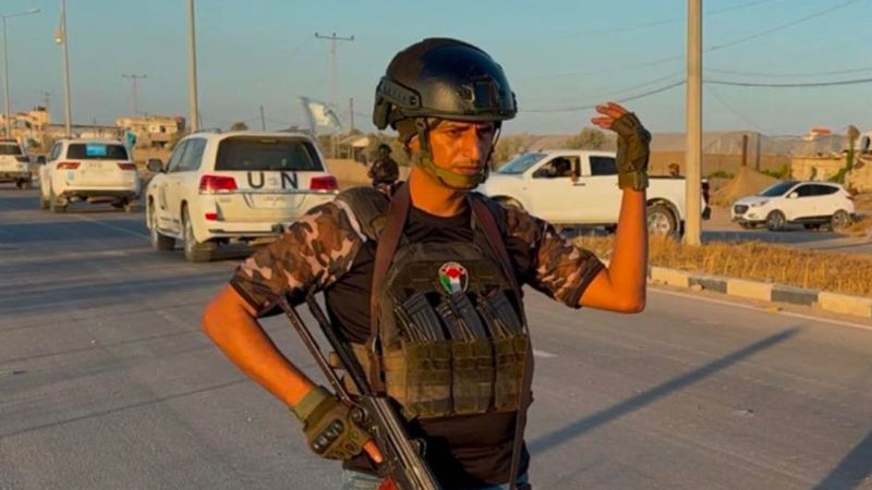 Снимката показва строен загорял мъж в тъмна каска Той схваща