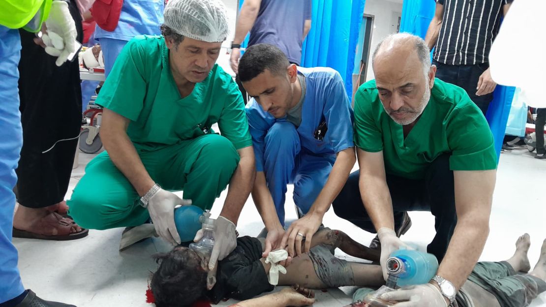 Palestinian surgeon Al-Bursh (left) is pictured treating a wounded Palestinian child at a hospital in Gaza.