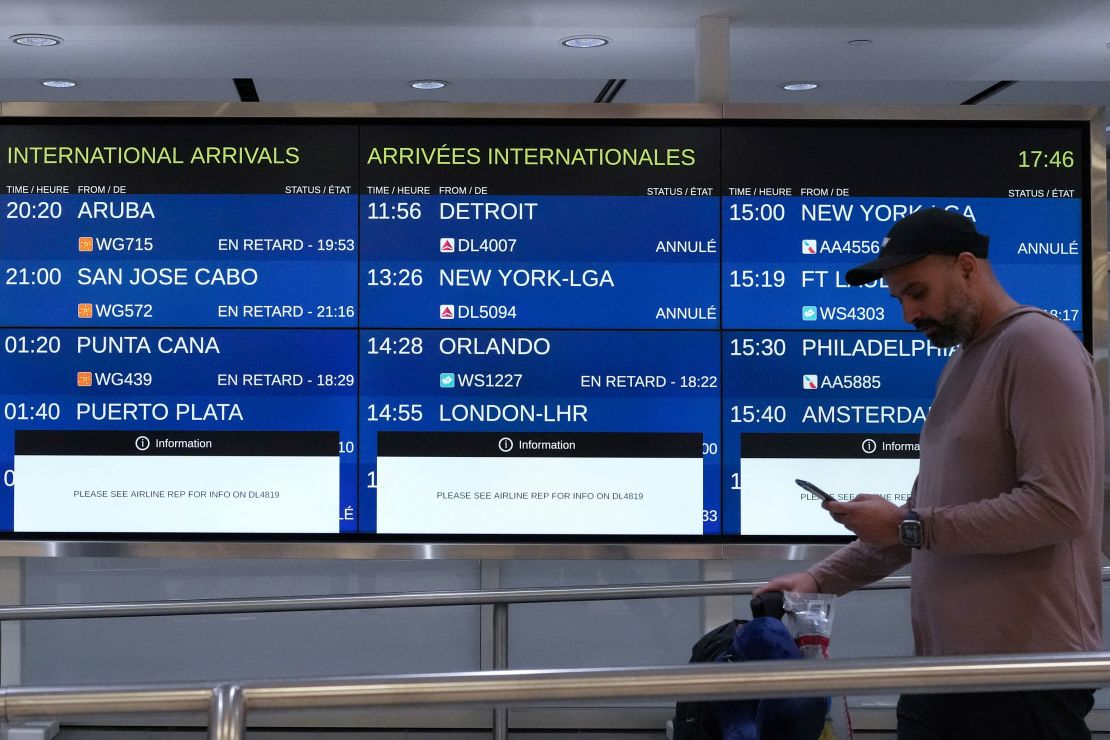 A person is seen in front of sign boards listing delayed and canceled flights inside Toronto Pearson International Airport on Monday.