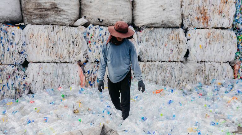 A man works on a mountain of plastic bottles prepared for recycling at an informal center in the city of Bangkok, Thailand.