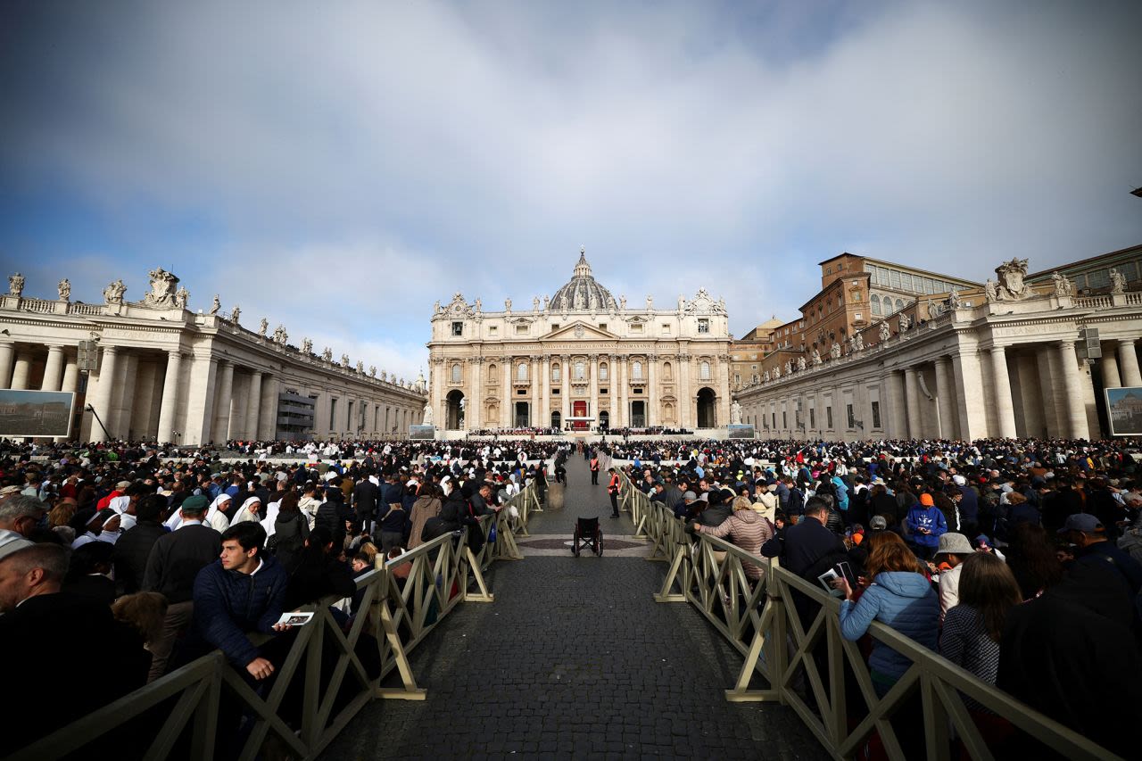 La gente espera mientras se reúne antes de la misa funeral del papa Francisco en la Plaza de San Pedro del Vaticano el sábado.