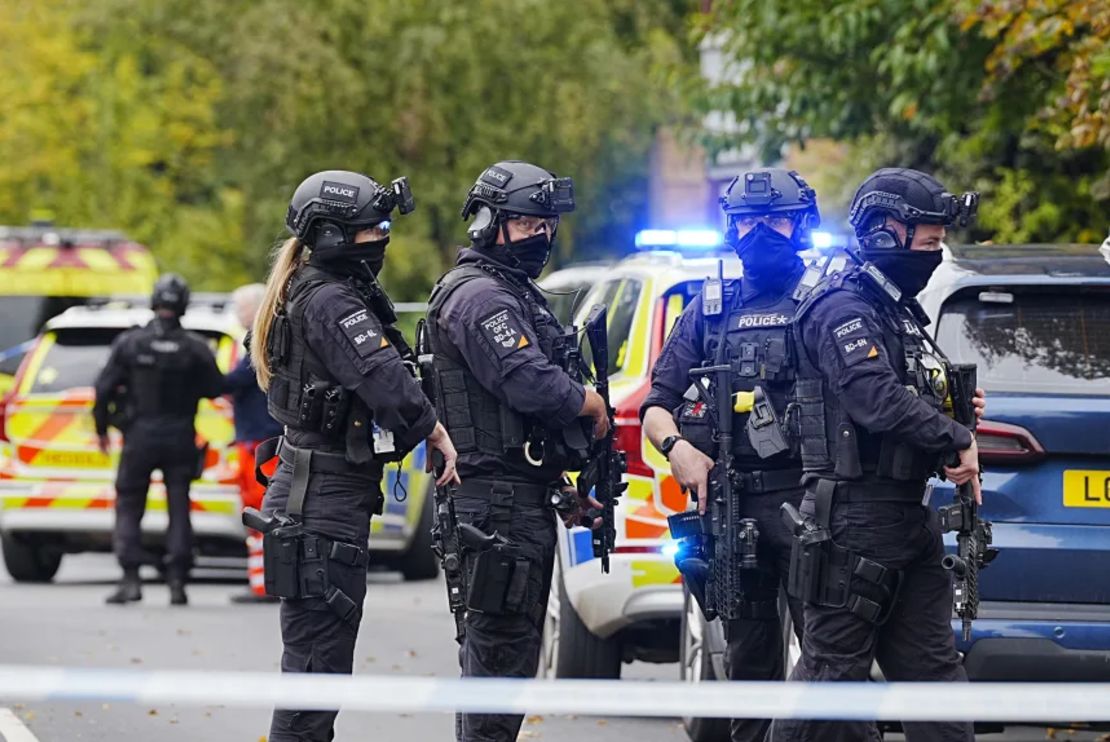 Agentes armados se alinean tras un ataque mortal frente a una sinagoga en Manchester, norte de Inglaterra. Legisladores británicos anunciaron un aumento de la presencia policial cerca de los lugares de culto judíos.