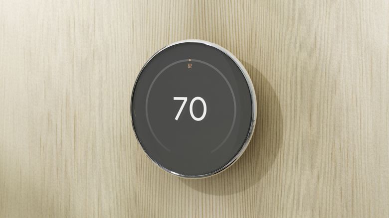 The silver Nest Learning Thermostat (2024) on a light wood wall, with a 70 degree readout