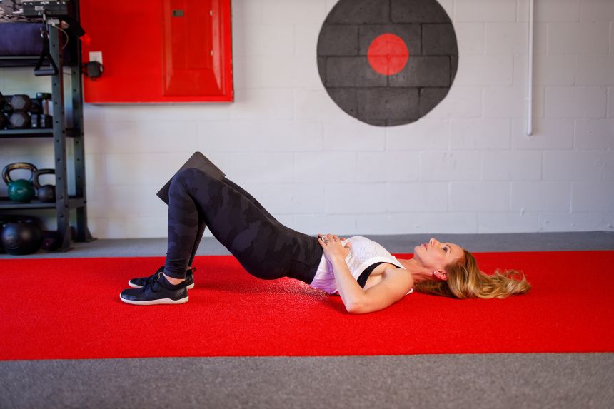 While exhaling, gently squeeze the yoga block as you lift your hips into a bridge position.