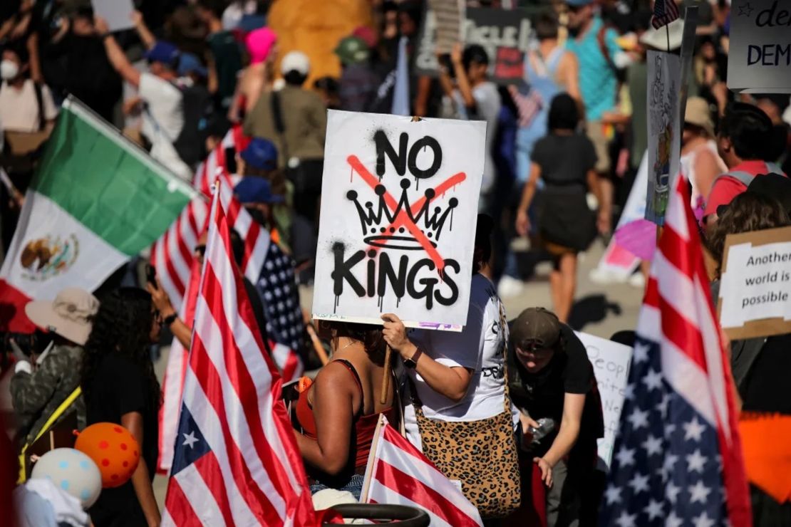 Un manifestante sostiene un cartel que dice "No Kings" frente al Ayuntamiento de Los Ángeles el sábado.