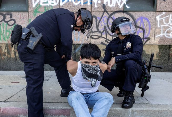 Oficiales detienen a un manifestante cerca del Centro de Detención de Los Ángeles el domingo.