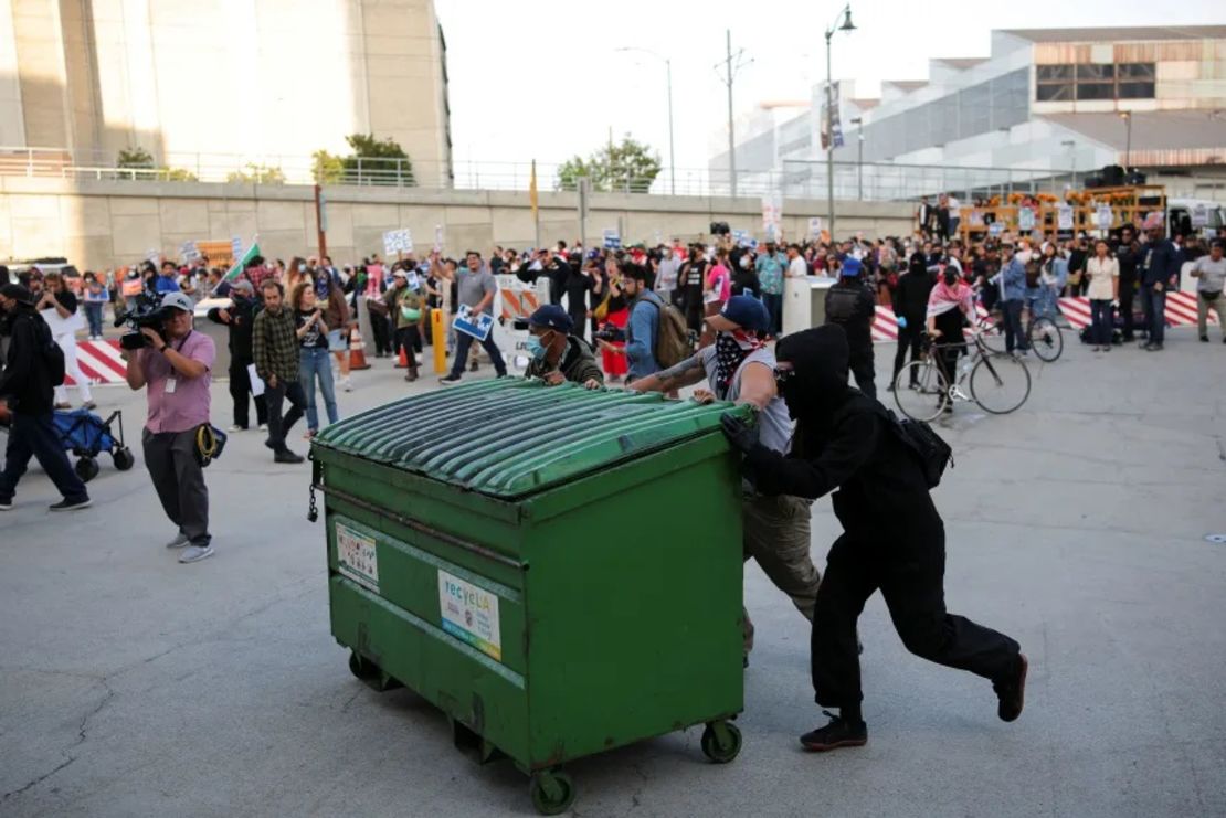 Manifestantes empujan un carrito de basura mientras intentan bloquear la entrada al garaje del Edificio Federal de Los Ángeles.