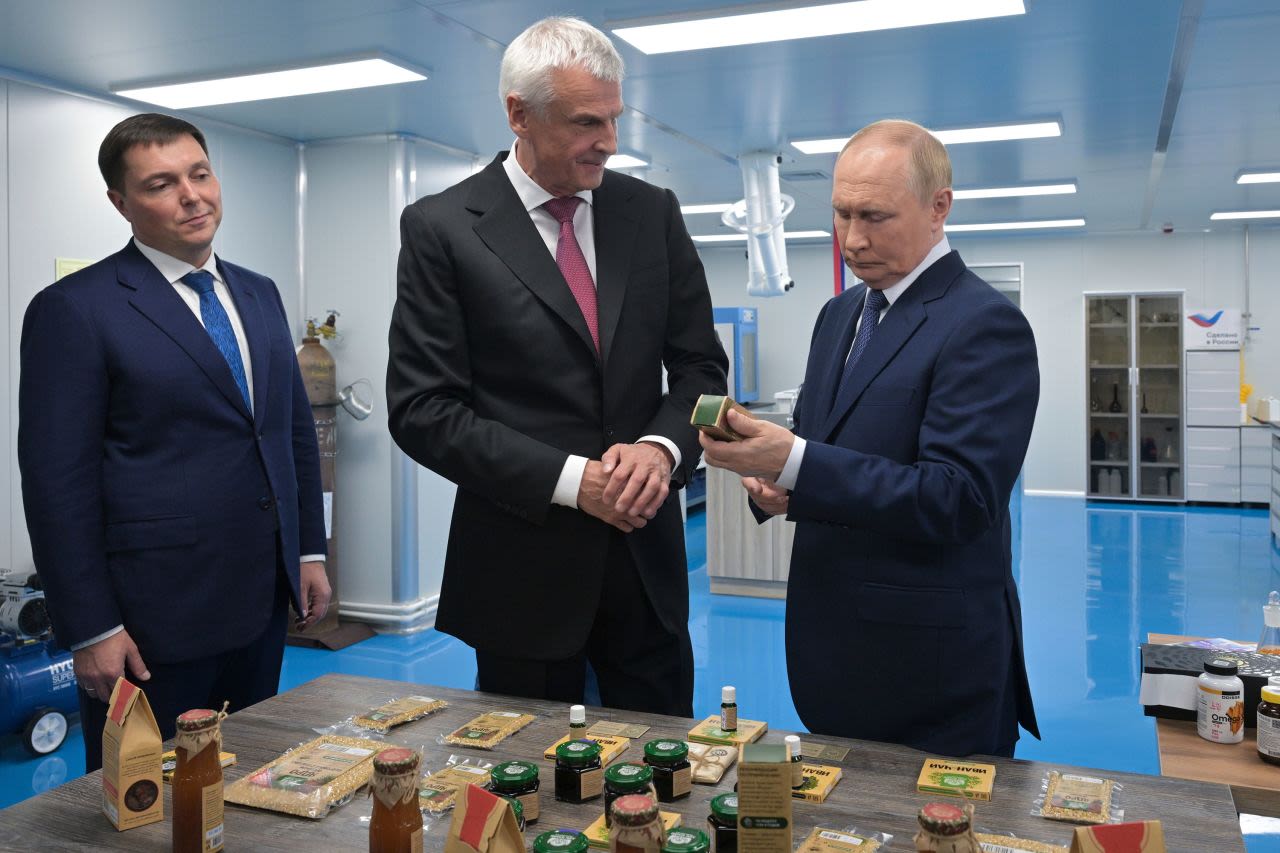El presidente Vladimir Putin escucha al gobernador de la región de Magadán, Sergei Nosov (centro), durante su visita a la planta de Omega-Si en Magadán, Rusia, este viernes.