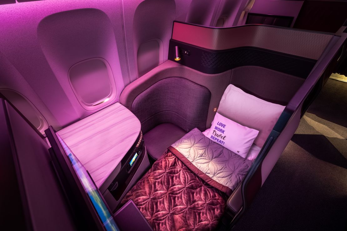 A photo of a Qsuite business class seat in the lie-flat position