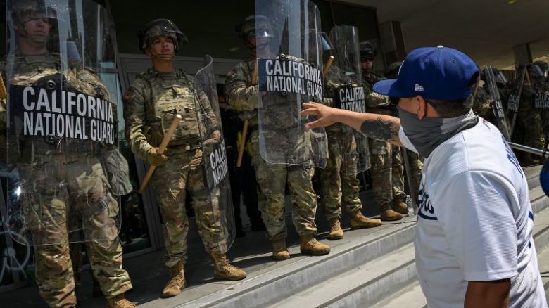  de la Guardia Nacional de California observan a los manifestantes protestando frente al Centro de Detención Metropolitano el 9 de junio en Los Ángeles.