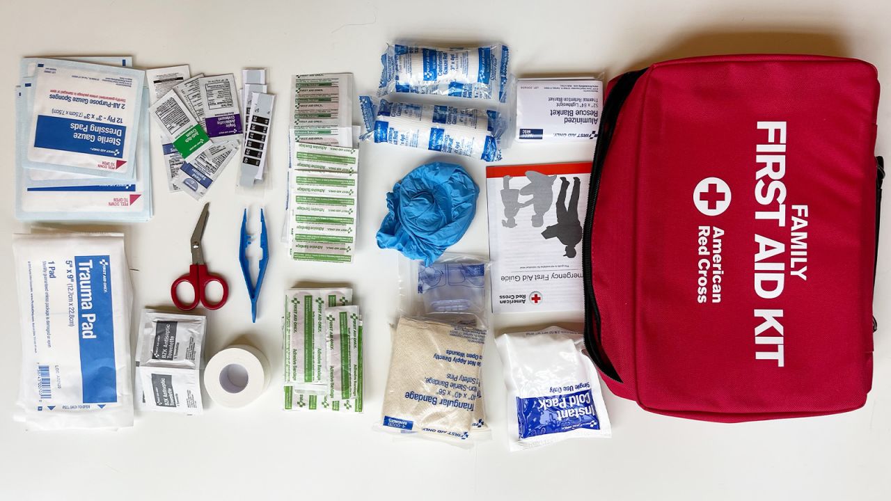 The American Red Cross Deluxe Family First Aid Kit, with contents laid out on a white tabletop